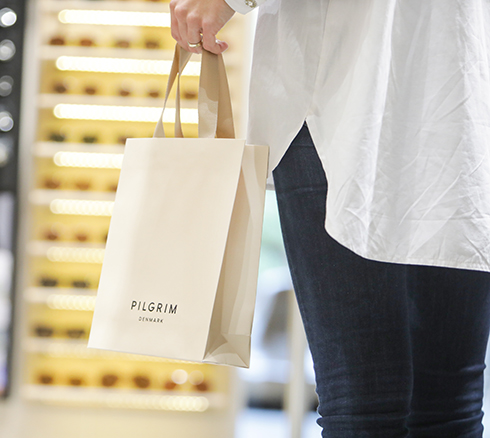 Kvinde går med en pose fra smykkebutikken Pilgrim i Slagelse. 
