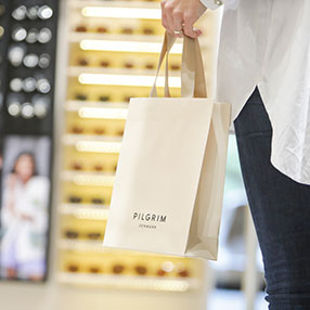 Kunde bærer en shoppingpose fra Pilgrim i VestsjællandsCentret