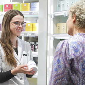Ekspedient viser plejeprodukt til kunde på apoteket i Slagelse