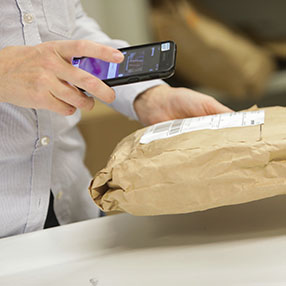 Ekspedient scanner en Postnord pakke på posthuset i Slagelse
